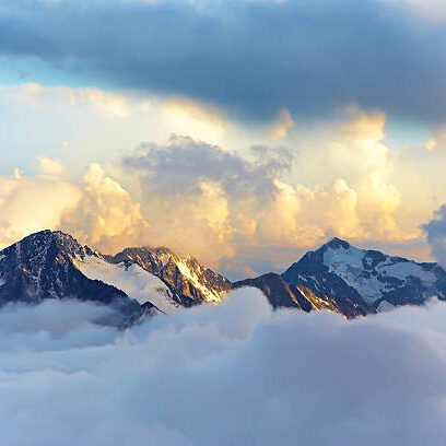 alpine landscape with peaks covered by snow and clouds